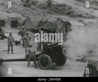 Artiglieri vietnamiti sparano da una posizione di montagna durante l'addestramento sul campo, 1962. Foto Stock