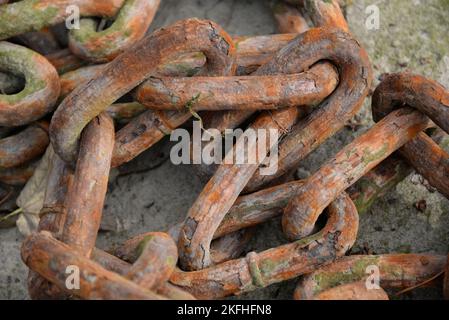Rustico colorato primo piano immagine di maglie in metallo catena collegati tra loro e sdraiato sul pavimento. Foto Stock