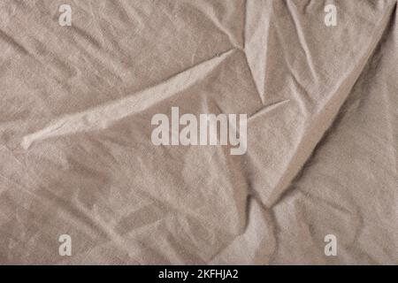 La struttura del tessuto stropicciato è grigio scuro. Tessuto grigio con grandi pieghe, vista dall'alto. Per sovrapposizione texture o design Foto Stock