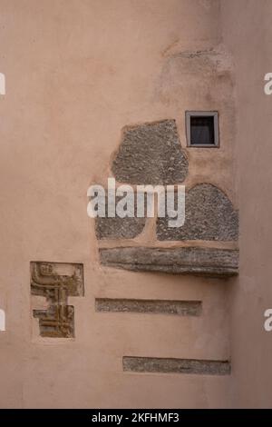 Estonia, Tallinn - 21 luglio 2022: Cattedrale di San Pietro e San Paolo. Primo piano di vecchie pietre e intaglio esposto su parete interna beige con piccolo vetro fr Foto Stock