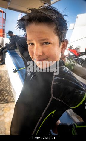 Ritratto di ragazzo caucasico sicuro indossare muta nera in piedi all'aperto mentre si gode la vacanza Foto Stock