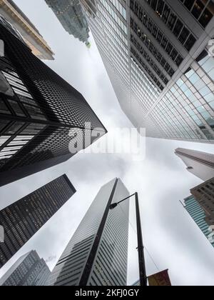 Vista ad angolo basso degli edifici degli uffici nel quartiere finanziario del centro con cielo nuvoloso sullo sfondo Foto Stock