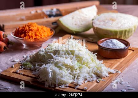 Preparare il cavolo per la fermentazione. Taglio del cavolo sulla taglierina. Crauti fatti in casa. Foto Stock