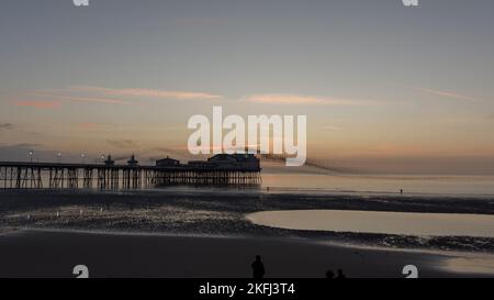 Murmurazione degli stellati alla fine del North Pier Blackpool. Stillings che floccano insieme sopra il molo. Tramonto mozzafiato con sagome sul molo Foto Stock