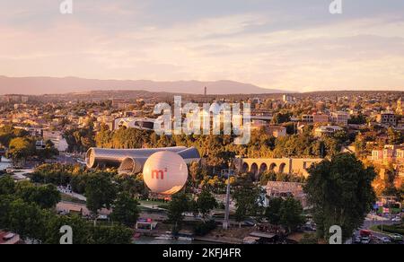 Tbilisi, Georgia - 07 23 2022: Tramonto estivo veduta aerea della città di Tbilisi Tiflis la capitale della Georgia con sala concerti Rike, parco Rike Foto Stock