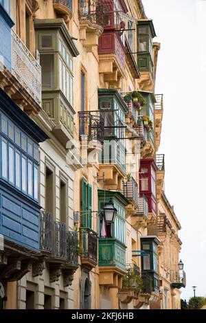 Valletta, Malta - 12 novembre 2022: Facciate di edifici residenziali con colorati e tradizionali balconi in legno nella capitale di Malta Foto Stock