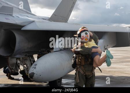 U.S. Marine Corps Sgt. Zachary Summers, ufficiale non commissionato Powerline in carica, Marine Fighter Attack Squadron (VMFA) 312, Marine Aircraft Group 31, abbraccia sua figlia dopo un volo a Marine Corps Air Station Beaufort, South Carolina, 19 settembre 2022. VMFA-312 ha offerto voli per Marines che si sono riarruolati come un modo per premiare la loro dedizione al corpo Marino. Foto Stock