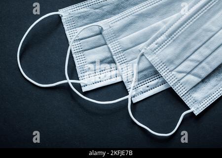 Maschere facciali sterili monouso su sfondo nero. Foto Stock