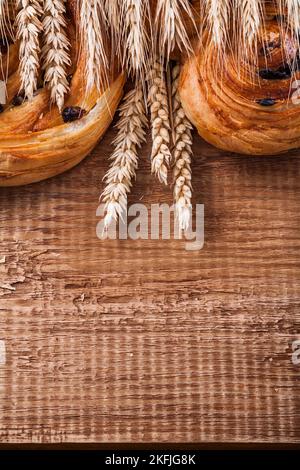 Spighe di grano maturo ricchi prodotti da forno a base di uva passa su un asse di legno di legno di oaken cibo e bevande concetto Foto Stock