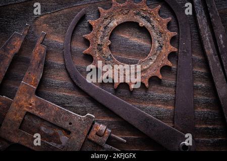 Set di calibri di misura arrugginiti con ruota dentata su costruzione di superfici in legno scuro vintage. Foto Stock