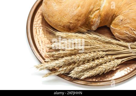 pagnotta di pane alle spighe di grano su vassoio di ottone vintage isolato bianco Foto Stock
