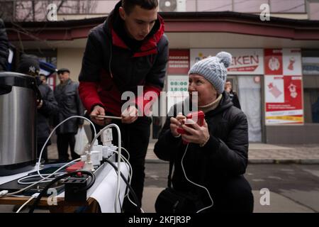 Kherson, Ucraina. 17th Nov 2022. I residenti vengono visti controllare e ricaricare i loro telefoni in un punto di ricarica temporaneo. I residenti di Kherson sono ancora troppo felici per la liberazione della città, ponendo fine a più di 8 mesi di occupazione. Tuttavia, la capitale regionale meridionale non ha ancora elettricità, acqua e un minimo di segnale e di approvvigionamento alimentare. Credit: SOPA Images Limited/Alamy Live News Foto Stock