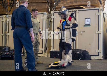 Aviation Boatswain's Mate (Handling) Airman Joseph Overmann, a destra, da Cedar Falls, Iowa, assegnato al primo vettore aereo della classe USS Gerald R. Ford (CVN 78) reparto aereo, toglie una tuta per lo smaltimento di dispositivi esplosivi mentre è istruito da Explosive Ordnance Disposal 2nd Classe Jake B. Bartlett, centro, da Salem, New Hampshire, Assegnato al plotone di smaltimento delle ordigni esplosive 6-2-2, 21 settembre 2022. Ford è in corso nell'Oceano Atlantico che conduce le qualifiche dei vettori e workups per un dispiegamento programmato questo autunno. Foto Stock