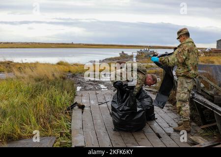 Personale della Guardia Nazionale dell'Alaska Sgt. John Cunningham, a sinistra, 176th Wing Maintenance Squadron, e SPC. Micheal Egoak, di Kethluk e un uomo di fanteria con 1st battaglione, 297th reggimento di fanteria, entrambi assaliti alla Joint Task Force-Bethel, elimina i detriti di tempesta da una passerella a Newtok, Alaska come parte dell'operazione Merbok Response, 22 settembre 2022. Circa 100 membri della milizia organizzata dell'Alaska, che include i membri della Guardia Nazionale dell'Alaska, della forza di Difesa dello Stato dell'Alaska e della milizia Navale dell'Alaska, sono stati attivati a seguito di una dichiarazione di disastro rilasciata il 17 settembre dopo i resti di Typhoon Foto Stock