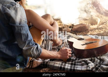 Prendere la vita facile... una coppia stesa su una coperta accanto ad una chitarra. Foto Stock