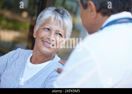 Thats buona notizia. Una donna anziana che parla con il suo medico. Foto Stock