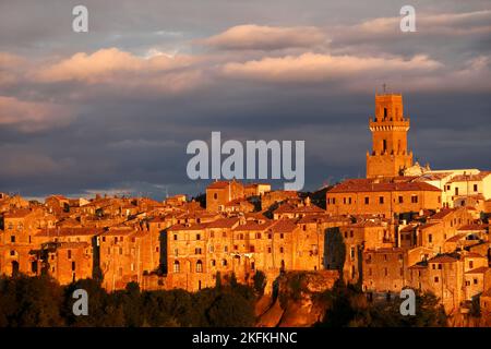 Primo piano e dettaglio della città medievale Pitigliano che illumina alla luce della sera la cattedrale Santi Pietro e Paolo e la torre nel centro, Maremma, Provin Foto Stock