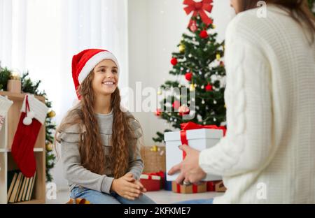 Un regalo di Natale in una scatola il giorno di Natale. Festeggia il nuovo anno con la tua famiglia. Foto Stock