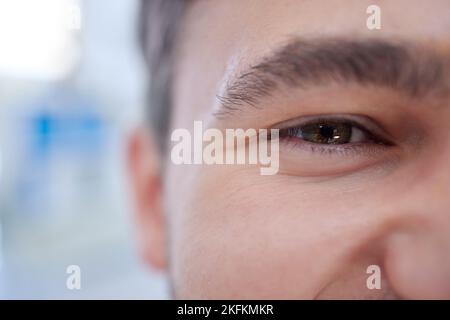 Ritratto felice, a metà e ad occhio dell'uomo con benessere, salute e buona visione in zoom marrone iris. Felicità, volto sano e positivo della persona soddisfatto Foto Stock