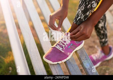 Indossa le scarpe da running e lascia correre. Immagine ritagliata di una donna che legava le scarpe. Foto Stock