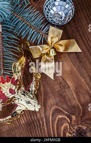 natale scheda specchio disco palla oro arco color oro maschera navale e ramo di pino su vecchia tavola di legno Foto Stock