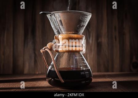 Metodo alternativo per preparare un delizioso caffè aromatizzato. Gocciolatore di caffè in vetro Intoo con acqua calda. Caffè al forno con ingredienti freschi e caldi. Vista ravvicinata. Foto Stock