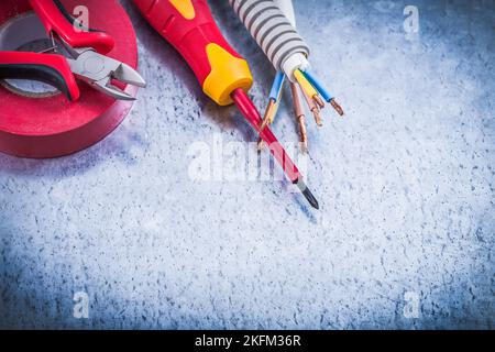 Pinza da taglio cacciavite isolato nastro isolante protettivo corrugato per tubi. Foto Stock