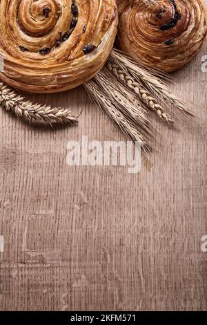 Panetti al forno a base di uva passa alle orecchie dorate su tavola di legno di legno e concetto di cibo e bevande. Foto Stock