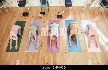 Yoga, studio e gruppo di donne anziane in pensione facendo un esercizio stretching per il corpo e la mente. Benessere, salute e anziani amici che fanno pilates Foto Stock