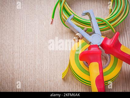 Nastro isolante cavo elettrico spelafili isolati su tavola di legno concetto di elettricità. Foto Stock