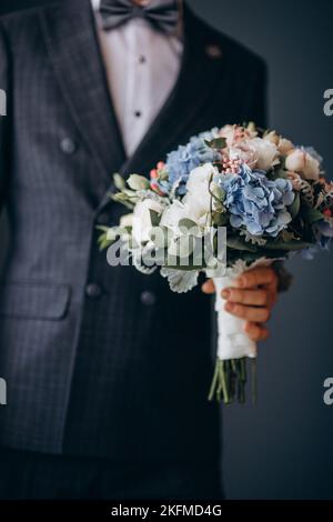 sposo che tiene il bouquet di nozze, giorno di nozze Foto Stock