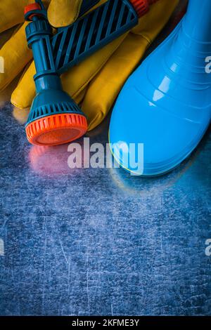 Set di stivali in gomma guanti di sicurezza in pelle e pistola da giardino. Foto Stock