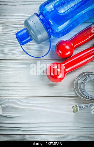 Tape misura plastica shaker manubri rossi su tavola di legno concetto di fitness. Foto Stock