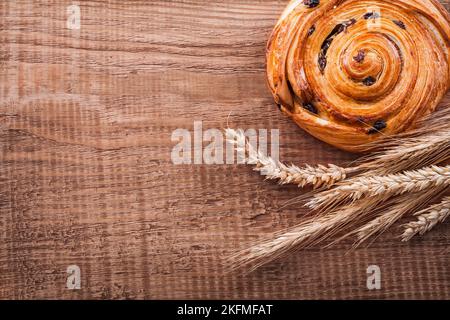 Mazzo di spighe di grano dolce con uva passa su tavola di legno di quercia concetto di cibo e bevande Foto Stock