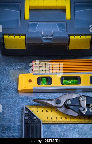 Cassetta attrezzi livello di costruzione metro in legno prova quadrato e acciaio taglierina su graffiato vintage metallo fondo concetto di manutenzione. Foto Stock