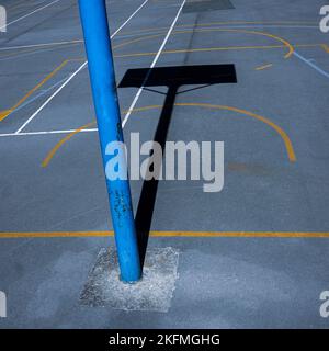 street basketballl hoop ombra sul campo sportivo Foto Stock