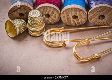 Spole in legno di fili di thimbles clasp spins su sfondo vintage. Foto Stock