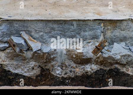 Macerie di cemento in un fossato in un cantiere Foto Stock