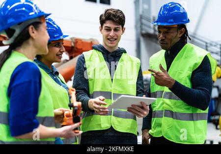 Team di ingegneri che lavorano in fabbrica robotica - concetto di industria tecnologica Foto Stock