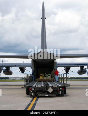 Appaltatori del 88th Logistics Readiness Squadron presso Wright-Patterson Air Force base, Ohio e Stati Uniti Air Force Airmen dal 1st Special Operations Wing, Hurlburt Field, Florida scaricare il carico da un MC-130J Combat Talon II Aircraft 27 settembre 2022. Aerei, attrezzature e Airmen sono stati riposizionati in WPAFB in preparazione di possibili impatti da parte dell'uragano Ian. Foto Stock