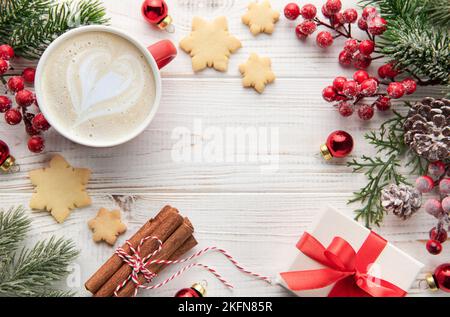 Tazza di caffè latte e decorazione natalizia su sfondo di legno bianco. Concetto di festa di Natale e Capodanno. Vista dall'alto con spazio di copia, piatta Foto Stock