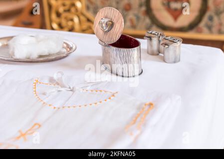 olio di chrisam in un vaso e acqua santa in una ciotola. Preparazione al battesimo sacramentale Foto Stock