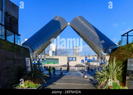 La scultura di Whittle Arch con dietro il Museo dei Trasporti. Millennium Place, Coventry, West Midlands, Inghilterra, Regno Unito Foto Stock