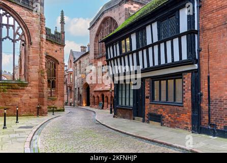 Numeri 22 e 23 Bayley Lane con le rovine della vecchia cattedrale a sinistra. Coventry, West Midlands, Inghilterra, Regno Unito Foto Stock