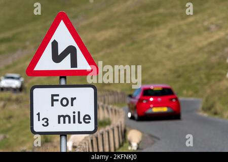 Indicazioni per Windy Road Ahead su una strada di brughiere al confine scozzese, Regno Unito. Foto Stock