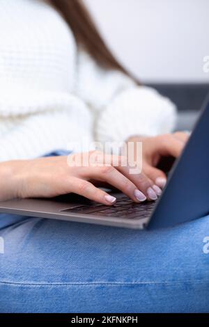 Primo piano delle mani femminili che premono la tastiera di un computer portatile. Una donna utilizza un notebook Foto Stock