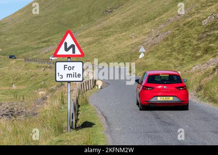 Indicazioni per Windy Road Ahead su una strada di brughiere al confine scozzese, Regno Unito. Foto Stock