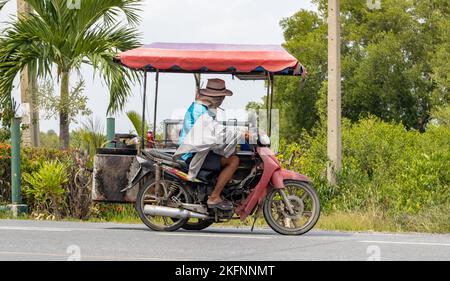 BANGKOK, THAILANDIA, 01 2022 GIUGNO, Un venditore di cibo guida un sidecar sulla strada Foto Stock