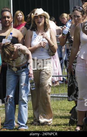 CHARLOTTE CHURCH, DANCING, HAT, 2005: Charlotte Church guarda e balla insieme a Daniel Bedingfield dal palco al Red Dragon Party nel Parco di Cardiff, Galles, 20 giugno 2005. Fotografia: ROB WATKINS. INFORMAZIONI: Charlotte Church, cantante e attrice gallese, ha raggiunto la fama di artista crossover classica in gioventù. Nota per la sua voce angelica, è passata al pop e ha pubblicato album come "Tissue and Issues", mostrando la sua versatilità. La carriera di Church comprende musica, TV e film, riflettendo i suoi diversi talenti. Foto Stock