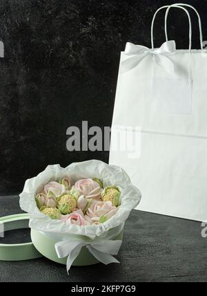 Un bouquet di fiori di zephyr - marshmallows in una bella scatola su uno sfondo scuro Foto Stock